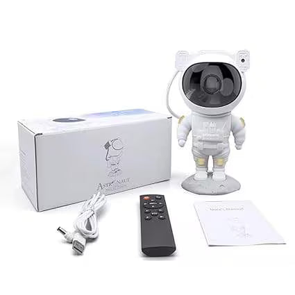 White astronaut-shaped camera with packaging, remote control, and cables on a white background